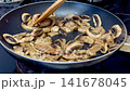 Mushrooms being fried in a frying pan, the process of cooking food. Concept. 141678045