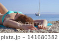 Close up of relaxing woman lying near calm sea. 141680382