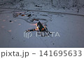 Aerial night view of snow-covered rural lodge with illuminated pathways 141695633