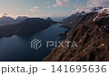 Aerial view of rugged coastal mountains and narrow fjord inlet at golden hour 141695636