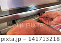 Close Up of Hands Inserting one hundred US Dollar Banknotes into ATM Cash Deposit Slot 141713218