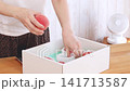 A woman's hands holding the delivered peaches and taking a picture with her smartphone. 141713587