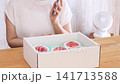 A woman calls the gift giver to thank them. 141713588