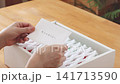 The scene of someone happily opening the box of shareholder benefits they received. 141713590