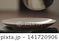 Slow motion hot penne pasta fall in deep plate closeup 141720906