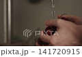 Slow motion closeup shot of man washing cherries with kitchen faucet 141720915