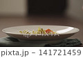 Slow motion making pesto penne pasta with mozzarella and tomatoes in deep plate closeup 141721459