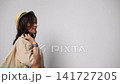Playful woman in a hat happily holding a reusable mesh bag full of fresh vegetables isolated on a white background 141727205