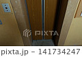 Worn elevator doorway with sliding wooden doors and scratched interior walls inside old building 141734247