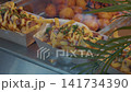 Loaded fries with melted cheese sauce and herbs served in paper trays at buffet counter 141734390