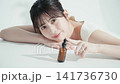 A young woman touching a serum bottle 141736730