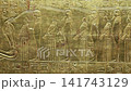 Closeup of golden Tutankhamun shrine panel with goddess and mummified figures relief. 141743129