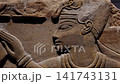 Extreme closeup of ancient Egyptian sandstone relief carving showing pharaoh profile face with crown and collar. Detailed hieroglyphic wall. 141743131