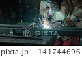Worker Welding Metal with Sparks in Workshop 141744696