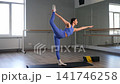 Graceful flexible sporty fit female practicing yoga dancer pose exercise, stretching chest, shoulders, and front of body, building stability in leg and core muscles in health club. 141746258