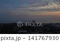 Golden sunrise over Hua Hin, Thailand, the sun reflecting across Gulf of Thailand. Condominiums and coastal buildings line shoreline beneath dramatic cloud filled morning sky. 141767930