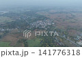 Heavy PM 2.5 haze blankets a rural village in Nong Bua Lamphu. Aerial view captures smog pollution covering the landscape during burning season in November 2023 141776318