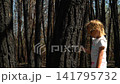 cheerful girl sunglasses white T-shirt stands burnt tree forest, touching hand, examining soot marks fingers pointing camera. It's sunny, bright spring day. consequences of a forest fire 141795732