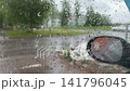 On a cloudy day, raindrops run down the car window. 141796045