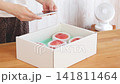 A woman's hands operating her smartphone after taking a picture of the peaches that arrived. 141811464