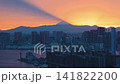 Mount Fuji Sunset Skyline Timelapse Aerial View over Urban Metropolitan Cityscape Featuring Golden Hour Light Rays Casting Long Shadows Across Skyscrapers and Waterfront 141822200