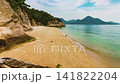 Japanese Coastline Scenic Timelapse Featuring Gentle Ocean Waves Lapping Onto a Pristine Sandy Beach with Lush Greenery and Mountain Silhouettes in 4k Resolution 141822204