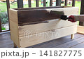Brown oil for protection of wood by staining. Painting fence for protecting and pests. Woodworker applying finish to pine board box. Repairman varnishing with brush wooden fencing wall plank surface. 141827775