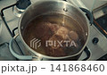 Meat bone broth cooking in a silver pot on a stove 141868460