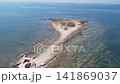 Aerial drone shot of the ancient Sipar archaeological site featuring historical ruins on a narrow rocky peninsula surrounded by the clear blue sea in Istria, Croatia. 141869037