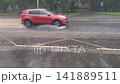 Speeding cars are driving along the highway in the pouring rain. 141889511