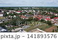 Aerial drone view showcasing the panoramic townscape of Vasarosnameny, Hungary, featuring residential houses, school buildings, and streets. 141893576