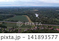 Aerial drone view capturing the M70 highway, lush green forests, river bends, and the village of Muraratka in Hungary. 141893577