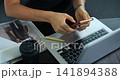 Relaxing while multitasking on electronic devices. Quick engagement with phone and computer during short break. Person simultaneously using mobile and laptop during relaxed interval of work 141894388