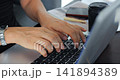 Casual work session with coffee and notes. Person using laptop in cafe environment with watch and journal. Individuals engaged in studying and notetaking at cozy cafe table with drinks 141894389