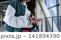Youthful confident portrait. Teenager in casual outdoor setting. Young man with calm look on pedestrian bridge. Teenage boy dressed casually standing confidently on modern bridge structure 141894390
