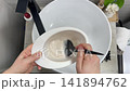 Hairdresser colorist mixes paint for hair dyeing bleaching. 141894762