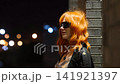 Portrait of a beautiful fiery red-haired woman on a city street at night. 141921397