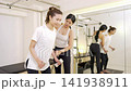 A woman receiving personal training and strength training instruction. A woman receiving personal training and strength training instruction. 141938911
