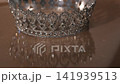 Luxury Gold Crown with Mirror Reflection and Sparkling Light on Beige Fabric Background.  141939513