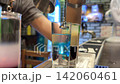 Blue Curacao Poured into Clear Vodka While Preparing a Bright Blue Cocktail Shot 142060461