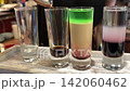 Bartender Preparing Colorful Layered Alcohol Shots with Liqueur at a Bar Counter 142060462
