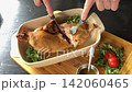 Tender Roasted Duck Falling Apart as Hands Cut Juicy Meat with Knife and Fork in Restaurant 142060465