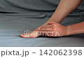 Person applying medicinal cream to a small skin injury on their ankle 142062398