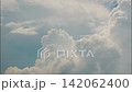 White puffy clouds drifting across a bright blue sky during a sunny afternoon capturing nature in motion 142062400