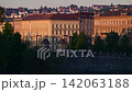 Ornate apartment facades along the Vltava River embankment in first sunlight, with trees below, Prague, Czech Republic 142063188