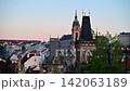 The Lesser Town Bridge Tower and the bell tower of St. Nicholas Church above red rooftops at dawn, Prague, Czech Republic 142063189