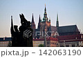 St. Vitus Cathedral and Prague Castle at dawn behind a silhouetted baroque statue group on Charles Bridge, Prague, Czech Republic 142063190