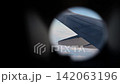View through an airplane porthole of the aircraft wing and winglet above a layer of clouds 142063196
