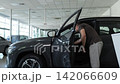 Male customer inspecting new car interior in dealership showroom 142066609