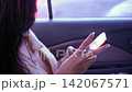 Close up of female passenger hands using smartphone while commuting in a car 142067571